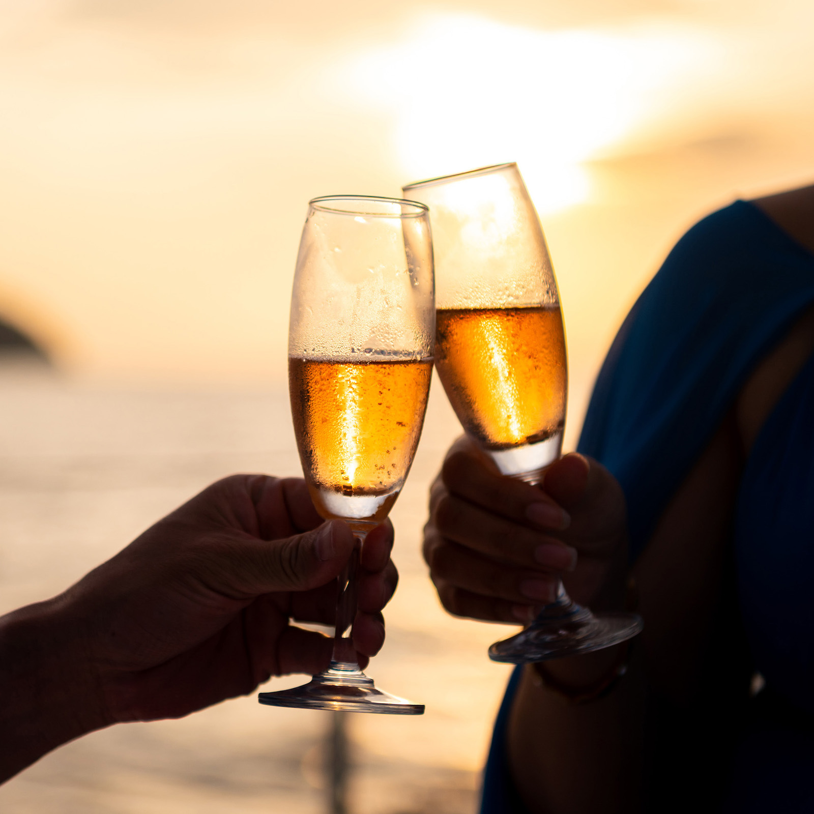 Hand,Holding,A,Glass,Drinking,Wine,On,Sunset,Sea,Background.